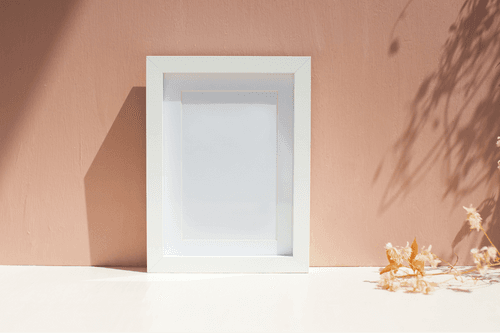 White Frame Mockup Against The Wall